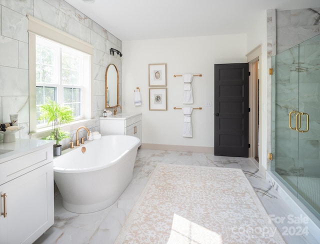 bathroom with vanity and shower with separate bathtub