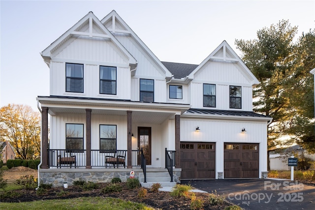 11330 James Coy Rd Covington, Unit Covington, Davidson, NC 28036 - modern farmhouse style home featuring a porch, an attached garage, a standing seam roof, a metal roof, and asphalt driveway