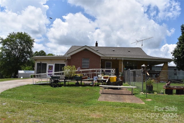 back of house with a sunroom and a yard