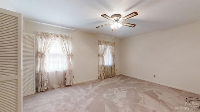 carpeted empty room featuring ceiling fan