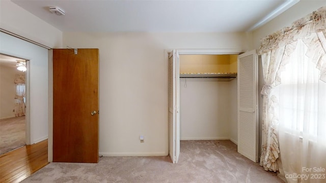 unfurnished bedroom with a closet and light wood-type flooring