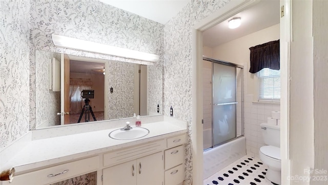 full bathroom with tile walls, toilet, tile flooring, shower / bath combination with glass door, and vanity