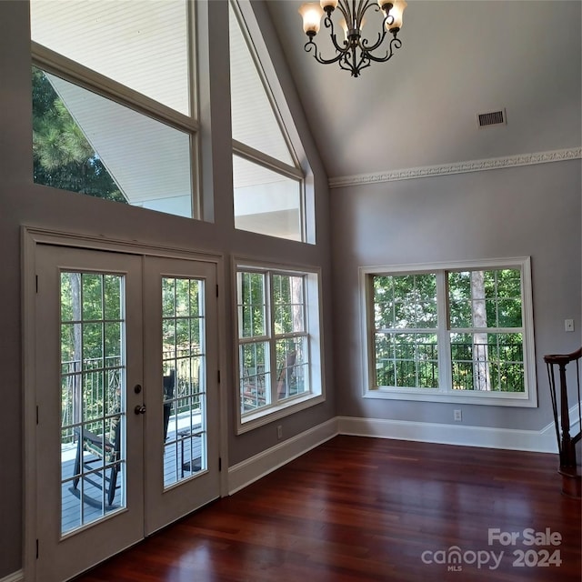 entryway with an inviting chandelier, high vaulted ceiling, dark hardwood / wood-style floors, and a healthy amount of sunlight