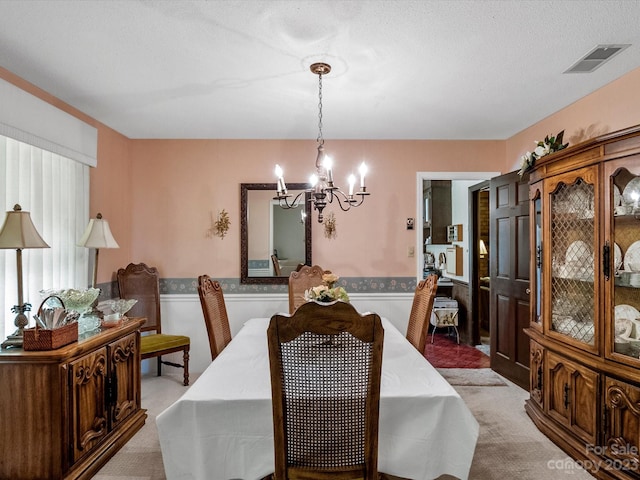 carpeted dining space with a chandelier