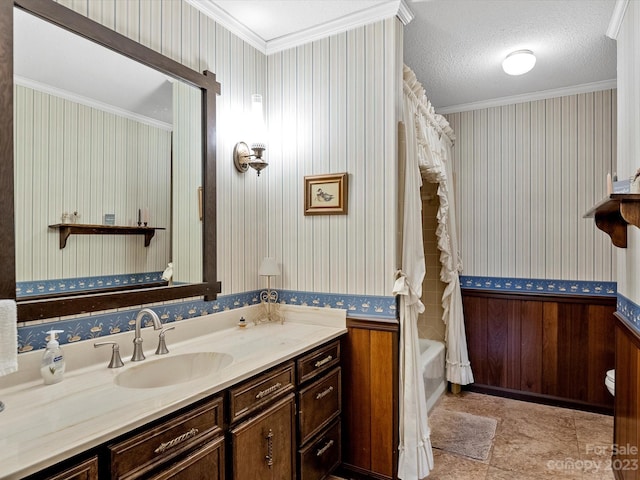 bathroom featuring a textured ceiling, ornamental molding, tile flooring, and vanity