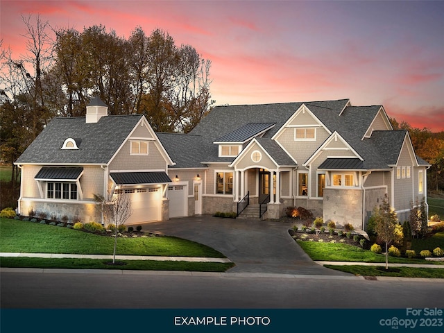 craftsman house with a lawn and a garage