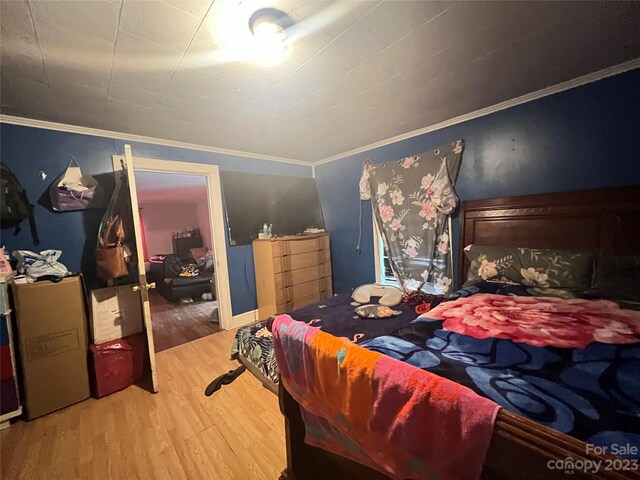 bedroom featuring light hardwood / wood-style flooring and ornamental molding