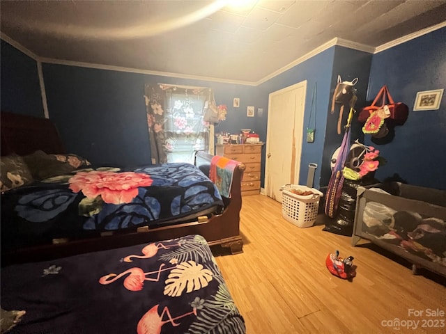 bedroom featuring crown molding and light hardwood / wood-style flooring