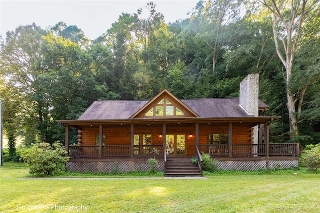 log cabin featuring a deck and a front lawn