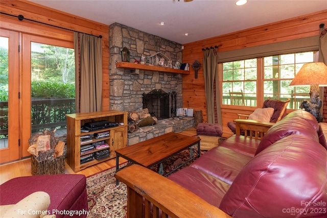 living room featuring wooden walls, a fireplace, and light wood-type flooring