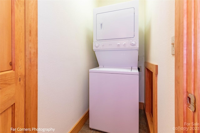 washroom featuring tile floors and stacked washer and dryer