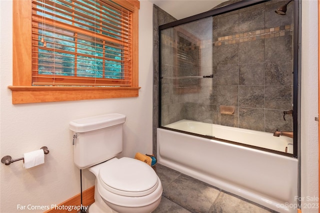 bathroom featuring tile flooring, enclosed tub / shower combo, and toilet