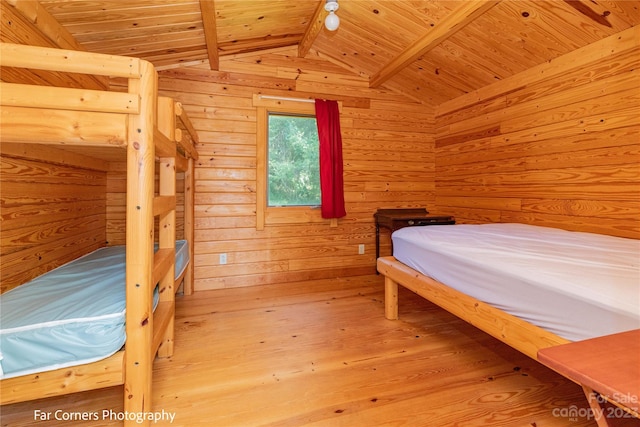 bedroom with wood walls, vaulted ceiling with beams, light hardwood / wood-style flooring, and wood ceiling