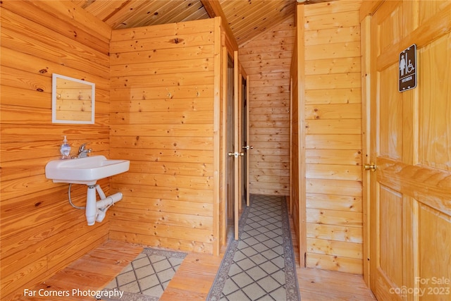 bathroom with lofted ceiling, wood ceiling, wooden walls, and hardwood / wood-style flooring