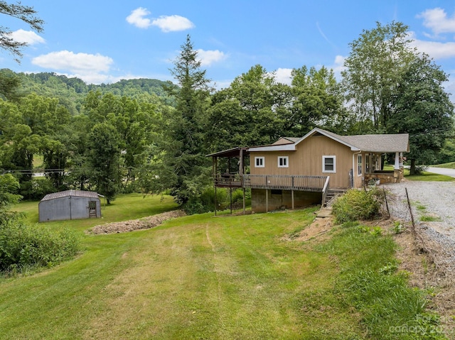 view of yard featuring a wooden deck and an outdoor structure