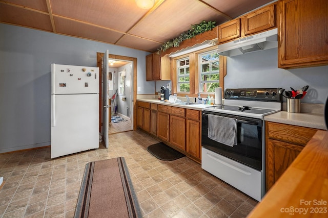 kitchen with light tile flooring, sink, and white appliances