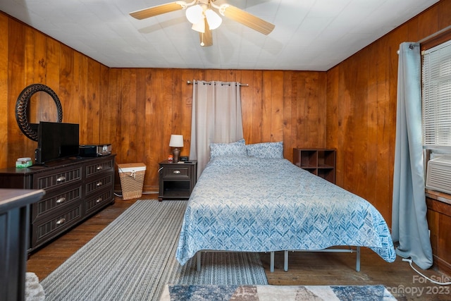 bedroom with dark hardwood / wood-style flooring, ceiling fan, and wood walls