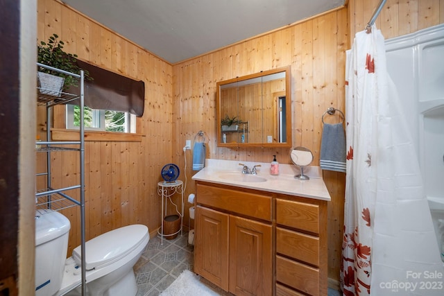 bathroom with wooden walls, toilet, vanity with extensive cabinet space, and tile floors