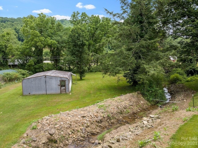 view of yard featuring an outdoor structure and a water view