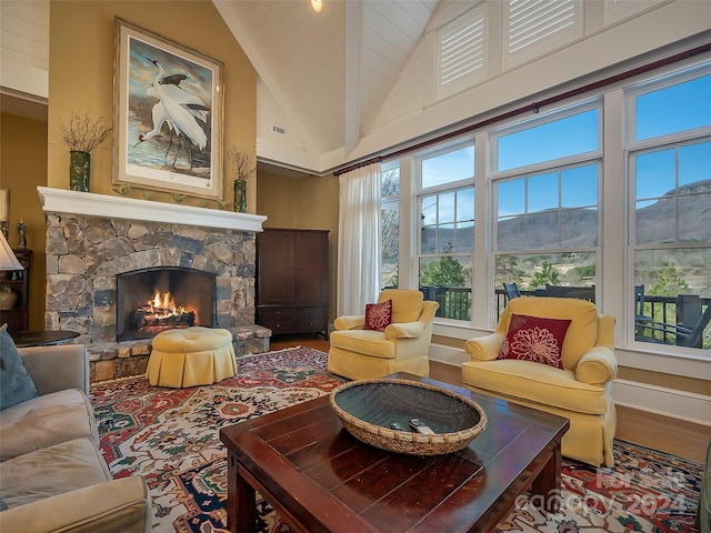 living room with high vaulted ceiling, wood-type flooring, and a fireplace