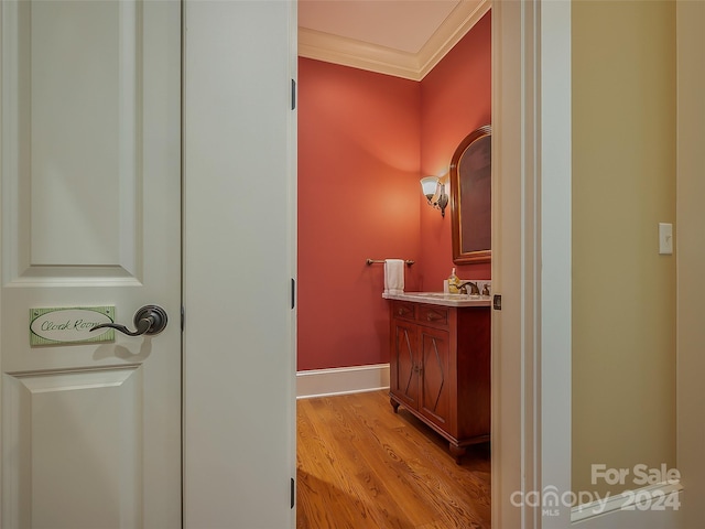 bathroom featuring ornamental molding, vanity, and wood-type flooring