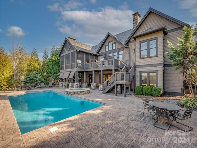 view of swimming pool with a wooden deck, a patio area, and an in ground hot tub