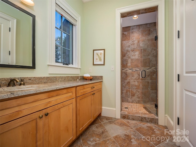 bathroom with tile floors, vanity, and a shower with shower door