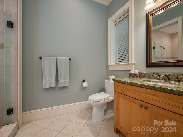 bathroom with tile floors, toilet, vanity, and tiled shower