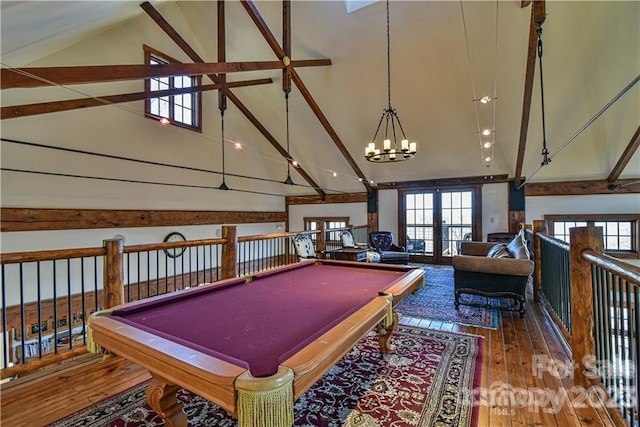 playroom featuring dark wood-type flooring, an inviting chandelier, billiards, high vaulted ceiling, and french doors