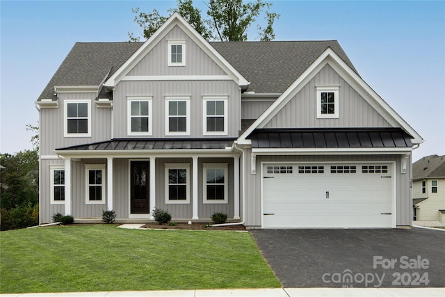 view of front of house with a shingled roof, a porch, a front yard, driveway, and a standing seam roof