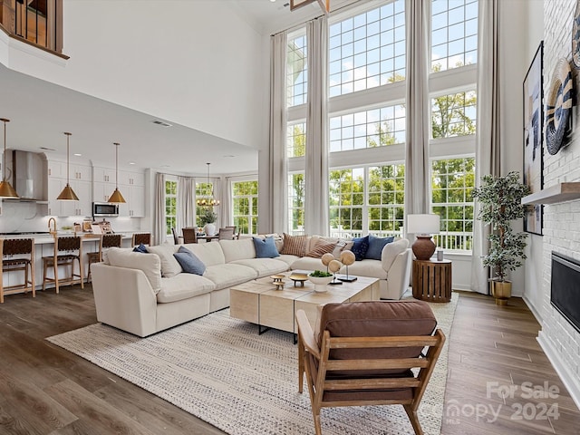 living area with visible vents, a high ceiling, dark wood-style flooring, and a fireplace