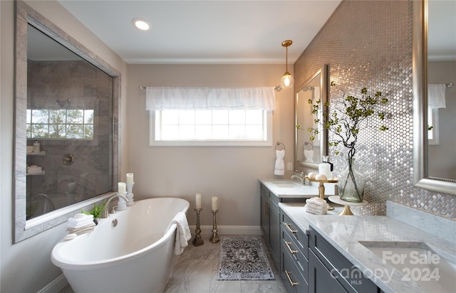 full bathroom with a sink, a tile shower, double vanity, baseboards, and a soaking tub