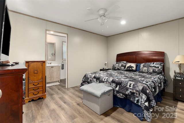 bedroom with ornamental molding, sink, light wood-type flooring, and ensuite bath