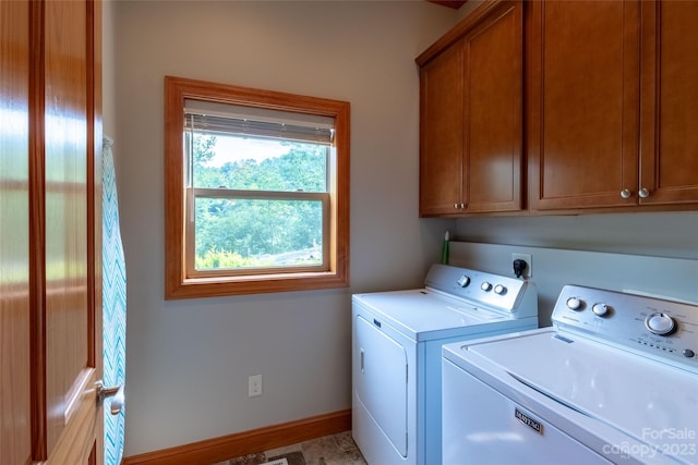 clothes washing area with hookup for an electric dryer, cabinets, and washing machine and dryer