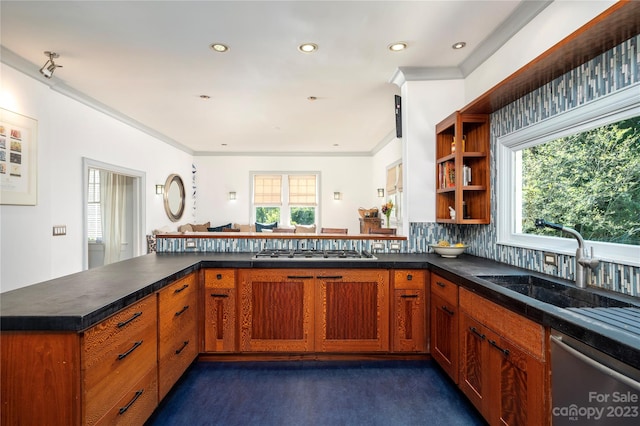 kitchen featuring backsplash, sink, stainless steel appliances, and kitchen peninsula