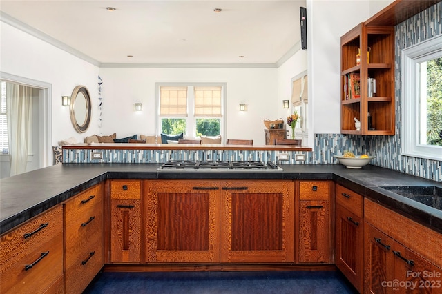 kitchen featuring backsplash, ornamental molding, stainless steel gas stovetop, and dark carpet