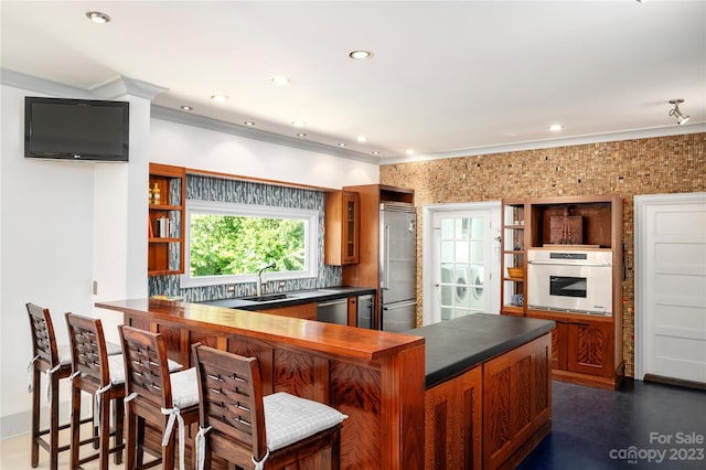 kitchen with a breakfast bar area, appliances with stainless steel finishes, tasteful backsplash, and sink