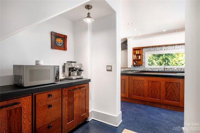 kitchen with hanging light fixtures, dark colored carpet, and tasteful backsplash