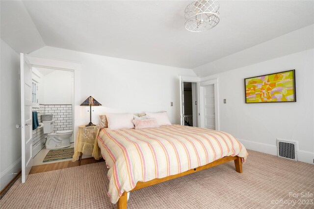 bedroom featuring connected bathroom and wood-type flooring