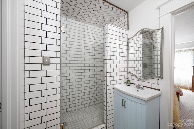 bathroom with vanity, tile walls, and tiled shower