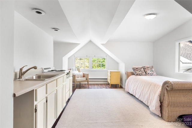 bedroom with vaulted ceiling, a baseboard heating unit, sink, and light wood-type flooring