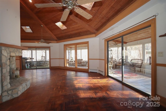 unfurnished living room featuring a skylight, ceiling fan, plenty of natural light, and wooden ceiling