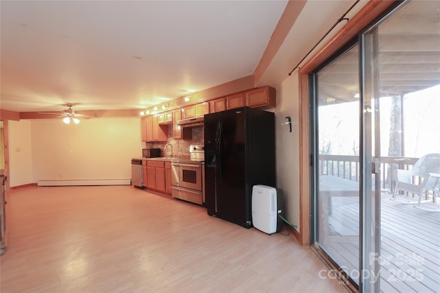 kitchen featuring appliances with stainless steel finishes, backsplash, ceiling fan, a baseboard heating unit, and sink