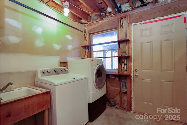 clothes washing area with washer and dryer and sink