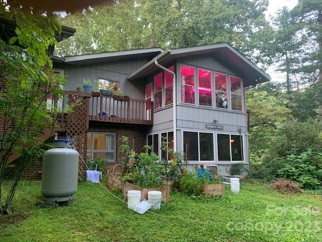 rear view of property with a balcony and a yard