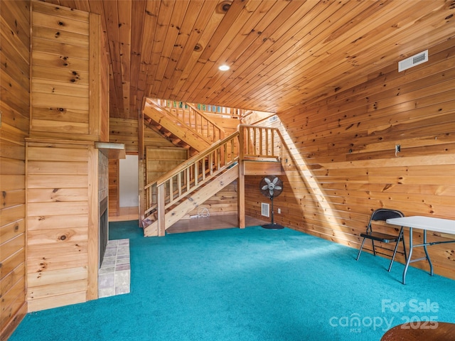 interior space with lofted ceiling, carpet floors, wooden ceiling, and wood walls