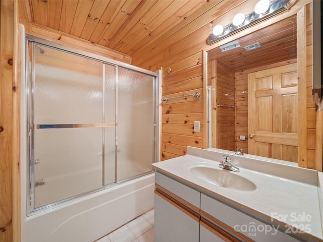 bathroom featuring tile patterned floors, wood ceiling, vanity, wooden walls, and enclosed tub / shower combo