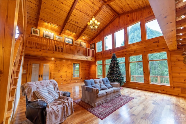 living room featuring an inviting chandelier, beamed ceiling, light wood-type flooring, high vaulted ceiling, and wood ceiling