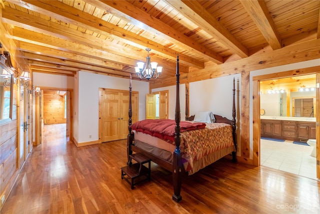 bedroom with connected bathroom, beam ceiling, wood ceiling, dark hardwood / wood-style floors, and an inviting chandelier