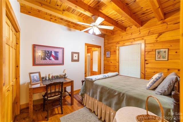 bedroom with ceiling fan, light wood-type flooring, wood walls, beam ceiling, and wooden ceiling